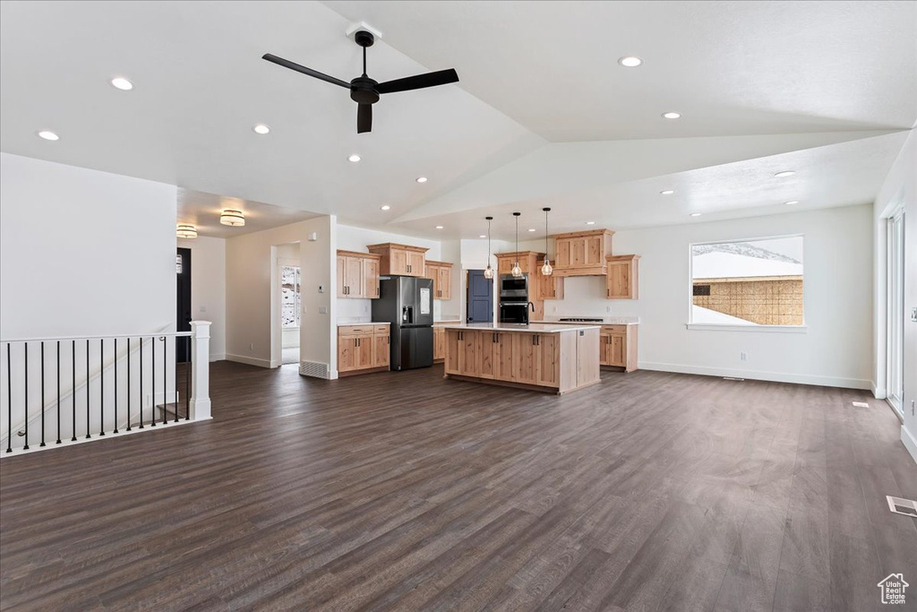 Kitchen featuring ceiling fan, a kitchen island, hanging light fixtures, dark hardwood / wood-style flooring, and appliances with stainless steel finishes