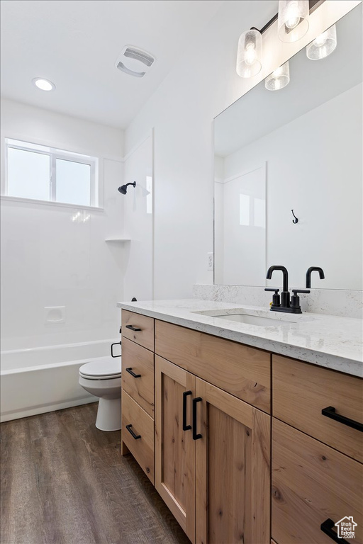 Full bathroom featuring shower / bath combination, toilet, large vanity, and hardwood / wood-style flooring