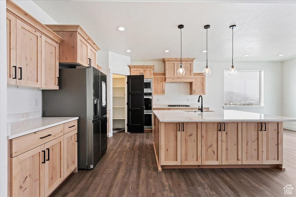 Kitchen with sink, a center island with sink, decorative light fixtures, dark wood-type flooring, and light brown cabinets