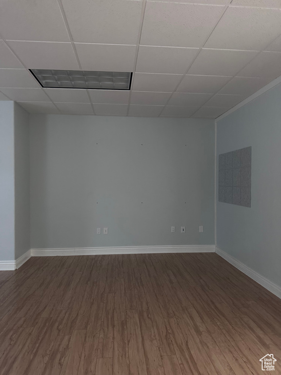 Unfurnished room with dark hardwood / wood-style flooring and a drop ceiling