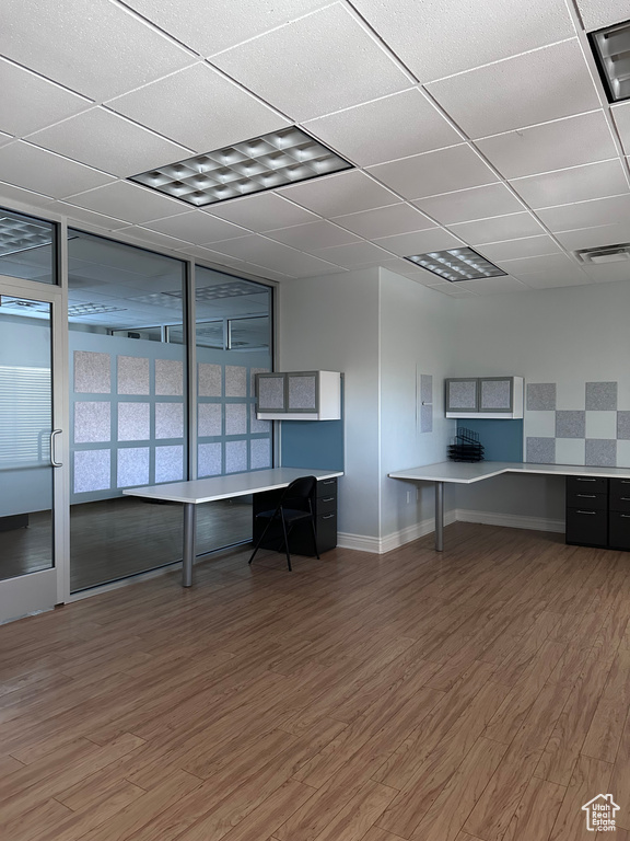 Unfurnished office with a drop ceiling and dark hardwood / wood-style floors