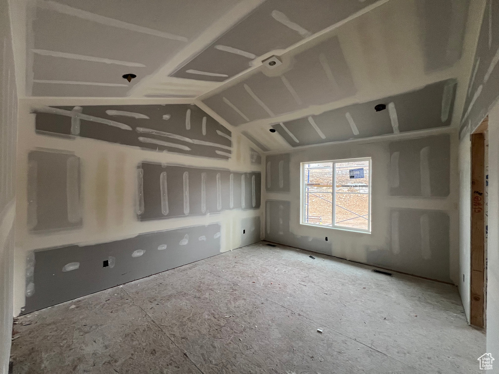 Unfurnished room featuring vaulted ceiling