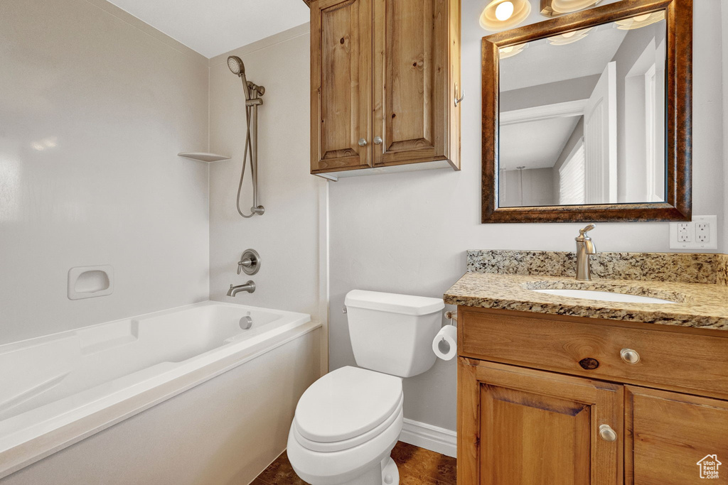 Full bathroom featuring vanity with extensive cabinet space, toilet, and shower / bathtub combination