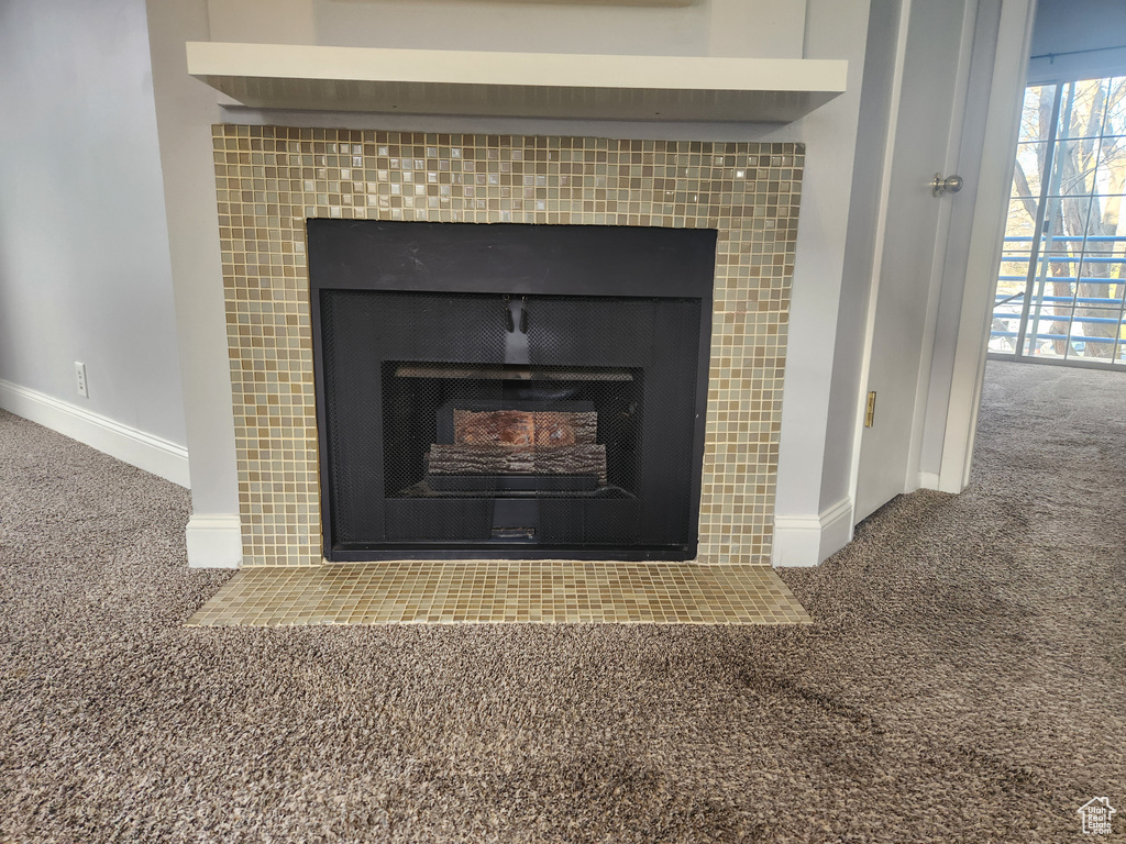 Room details featuring a tile fireplace and carpet flooring