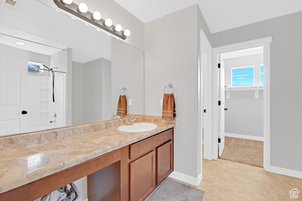 Bathroom featuring tile floors,  shower combination, and vanity with extensive cabinet space