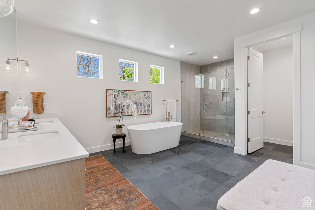 Bathroom with separate shower and tub, dual bowl vanity, and tile flooring