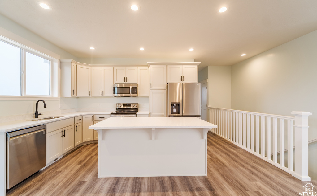 Kitchen featuring sink, a kitchen island, appliances with stainless steel finishes, and light hardwood / wood-style floors