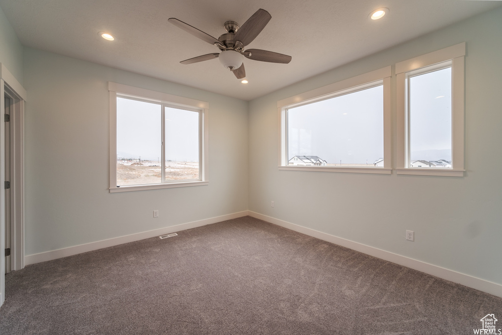 Carpeted empty room with ceiling fan