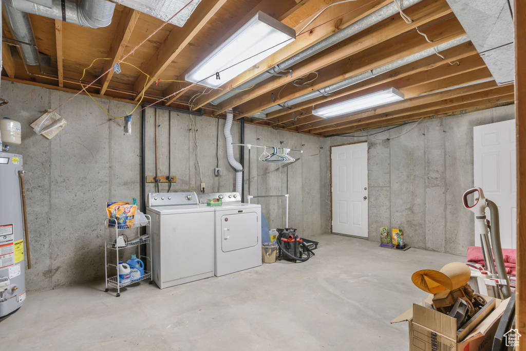 Basement with water heater and separate washer and dryer