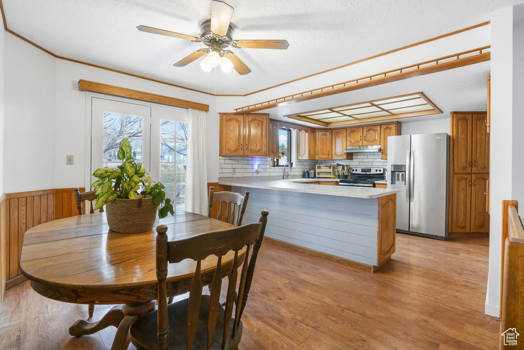 Dining area featuring sink, light hardwood / wood-style floors, french doors, and ceiling fan