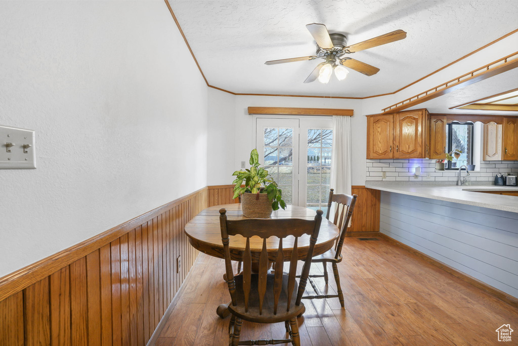 Dining area featuring crown molding, a wealth of natural light, light hardwood / wood-style flooring, and ceiling fan