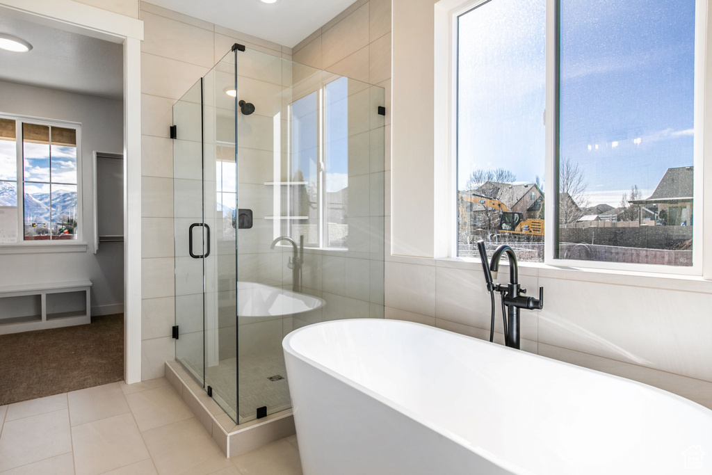 Bathroom with a wealth of natural light, separate shower and tub, and tile floors