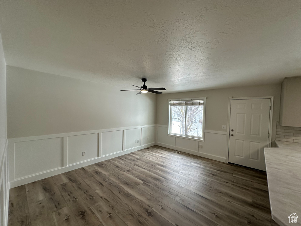 Unfurnished room with dark wood-type flooring, a textured ceiling, and ceiling fan