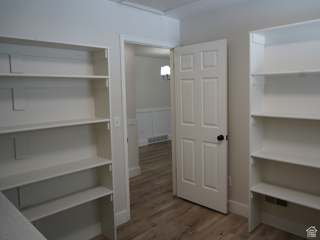 Spacious closet featuring dark hardwood / wood-style flooring