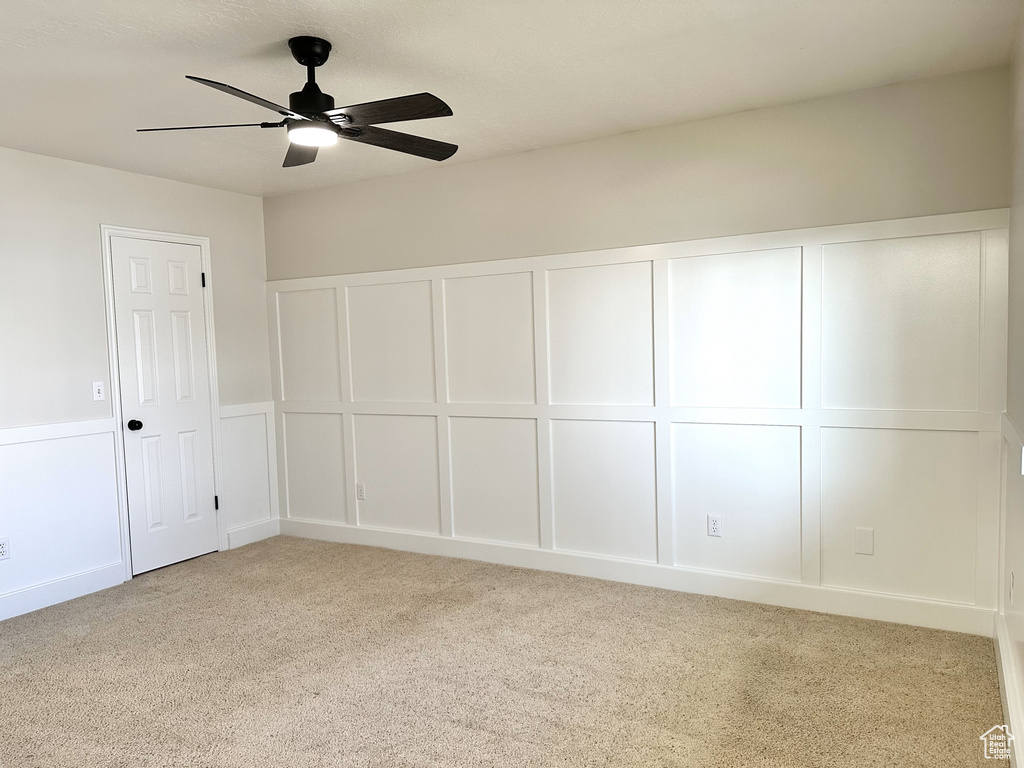 Carpeted empty room featuring ceiling fan