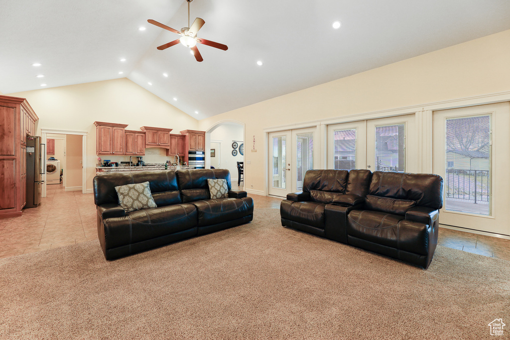 Carpeted living room with washer / dryer, french doors, high vaulted ceiling, and ceiling fan