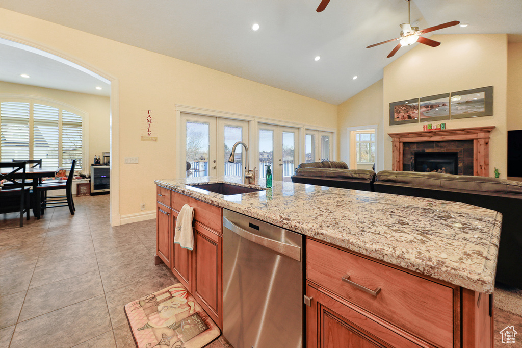 Kitchen featuring a kitchen island, ceiling fan, dishwasher, sink, and a fireplace