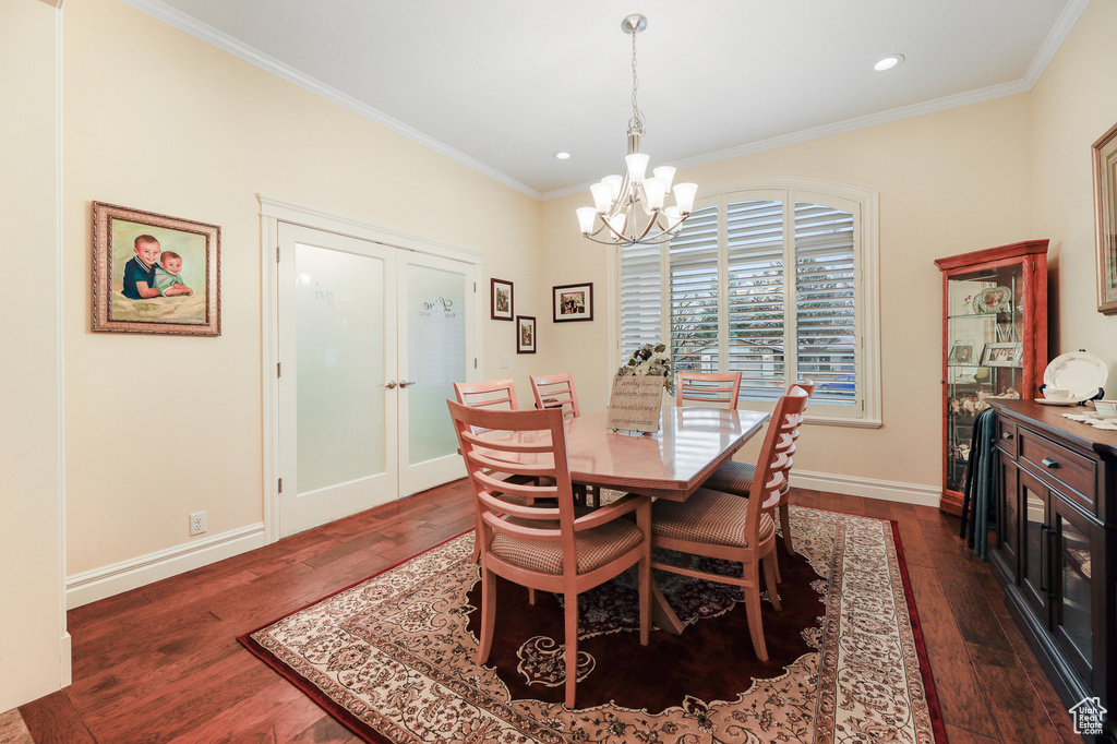 Dining room with crown molding, french doors, an inviting chandelier, and dark hardwood / wood-style floors