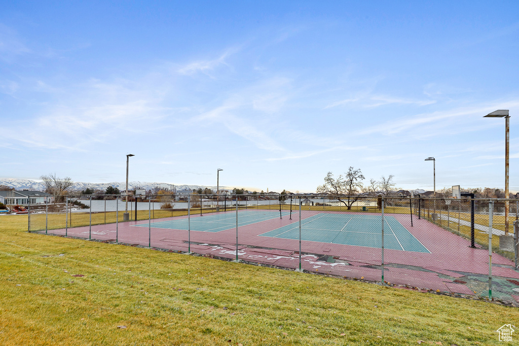 View of tennis court featuring a yard