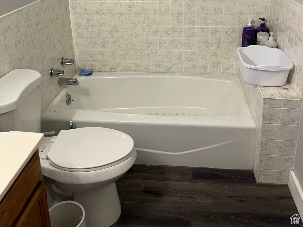 Bathroom with a bathtub, vanity, toilet, and hardwood / wood-style floors