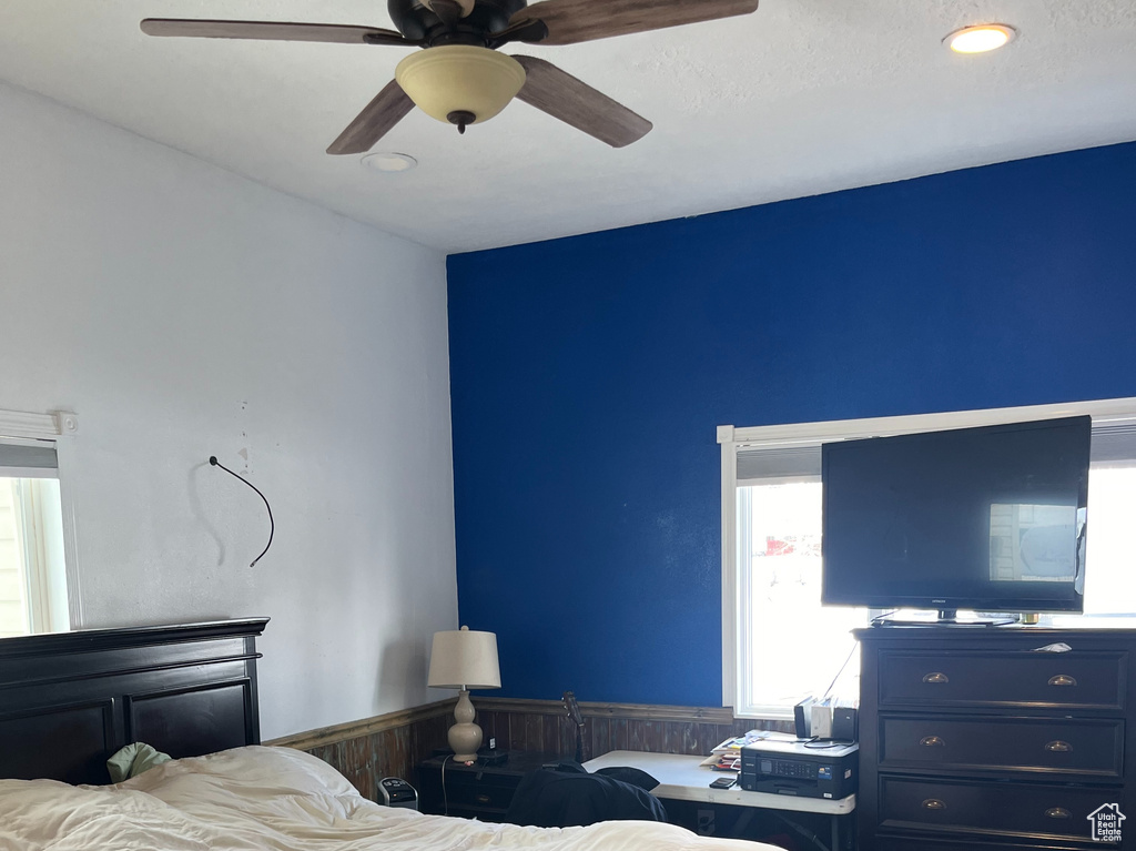 Bedroom featuring dark hardwood / wood-style flooring, multiple windows, and ceiling fan