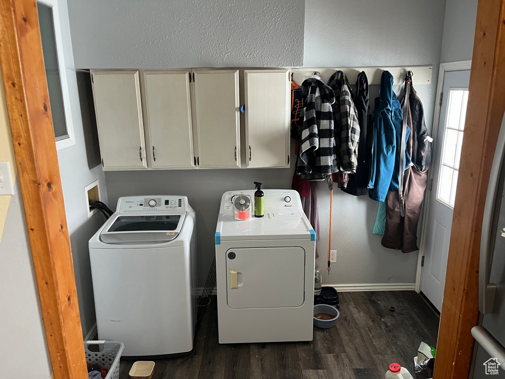Laundry room with dark wood-type flooring, independent washer and dryer, cabinets, and washer hookup