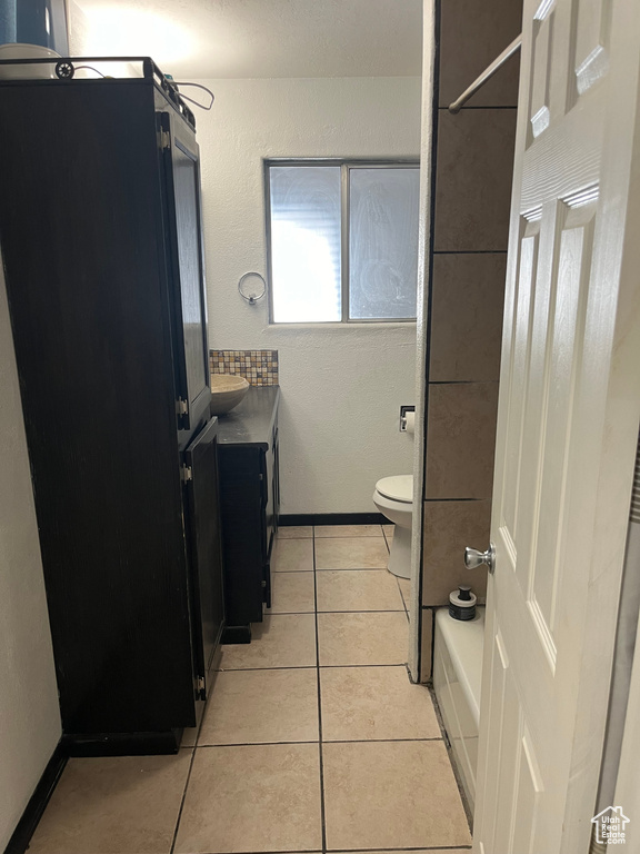 Full bathroom featuring toilet, vanity, bathing tub / shower combination, and tile flooring