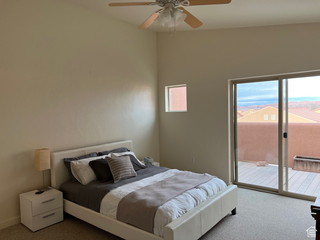 Carpeted bedroom with vaulted ceiling, access to exterior, and ceiling fan