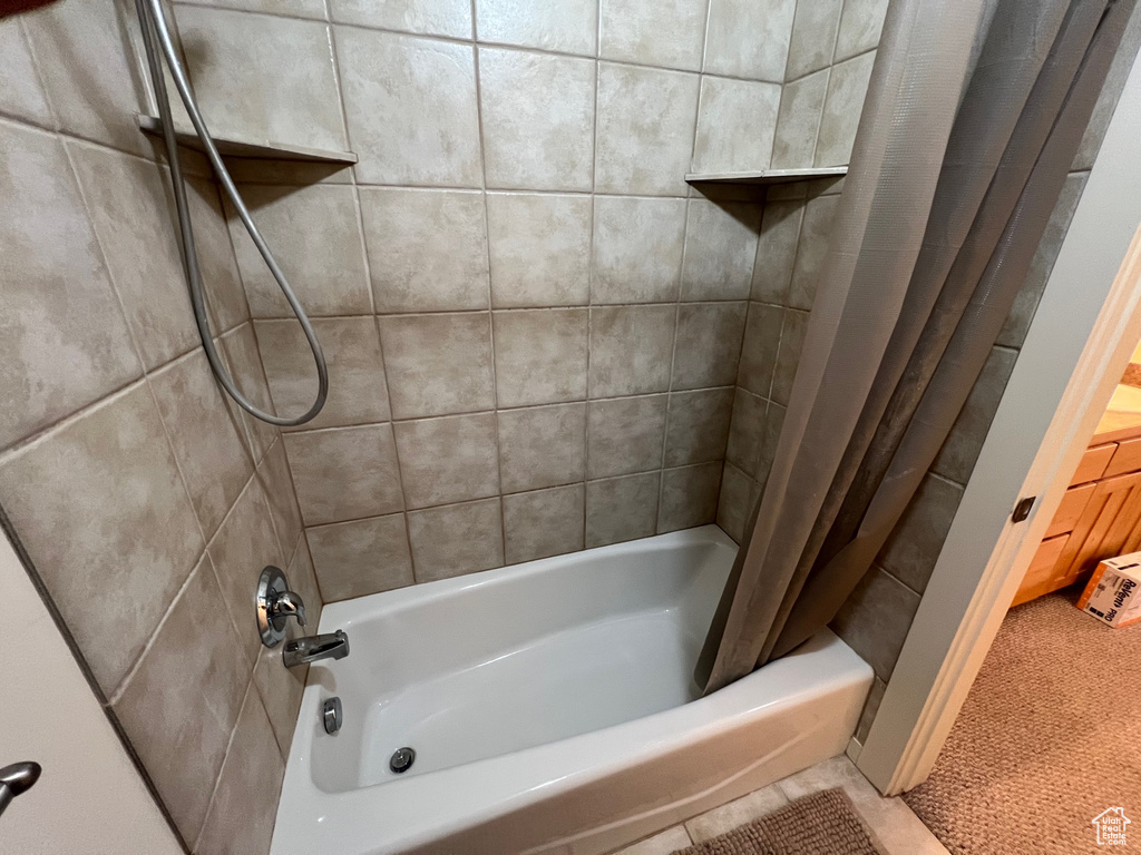Bathroom with tile floors and shower / bath combination with curtain