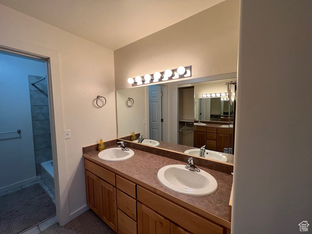 Bathroom with large vanity, shower / bath combination, and dual sinks