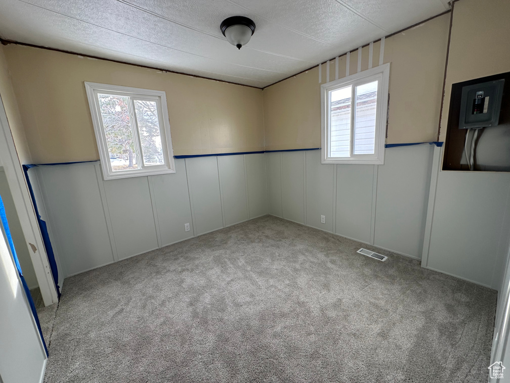 Carpeted spare room featuring a textured ceiling