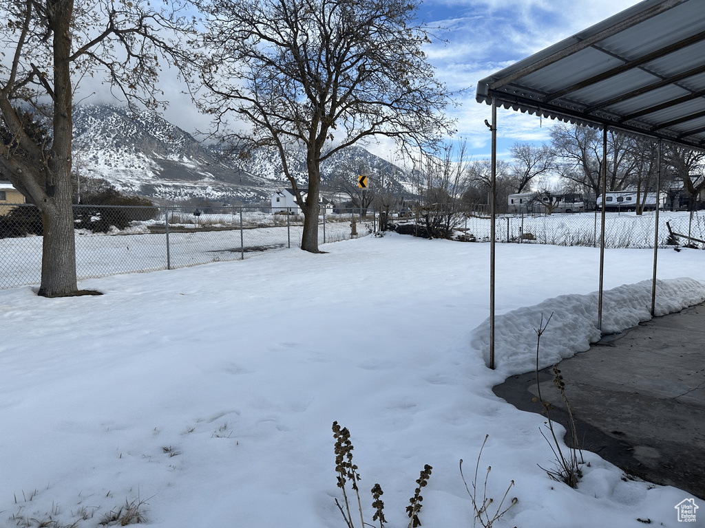 Yard covered in snow with a mountain view