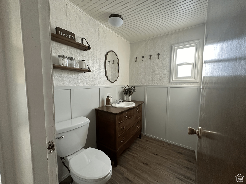 Bathroom featuring wood-type flooring, toilet, wood ceiling, and oversized vanity