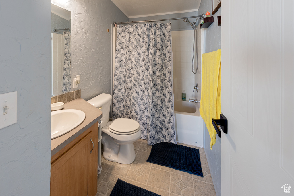 Full bathroom featuring toilet, vanity, shower / bath combo, and tile flooring