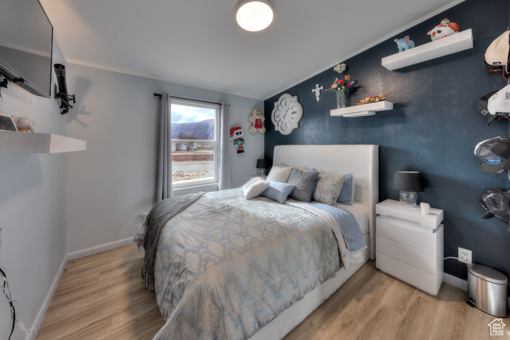 Bedroom featuring light hardwood / wood-style flooring and ornamental molding