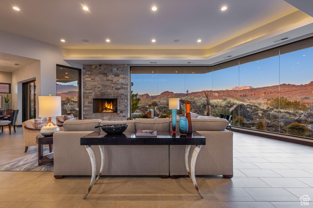 Tiled living room featuring a stone fireplace and a mountain view
