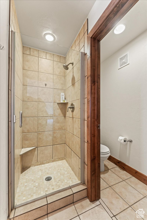 Bathroom with tile floors, toilet, and walk in shower