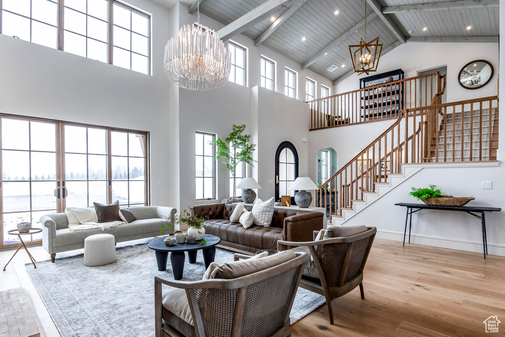 Living room featuring wood ceiling, high vaulted ceiling, a notable chandelier, and beam ceiling