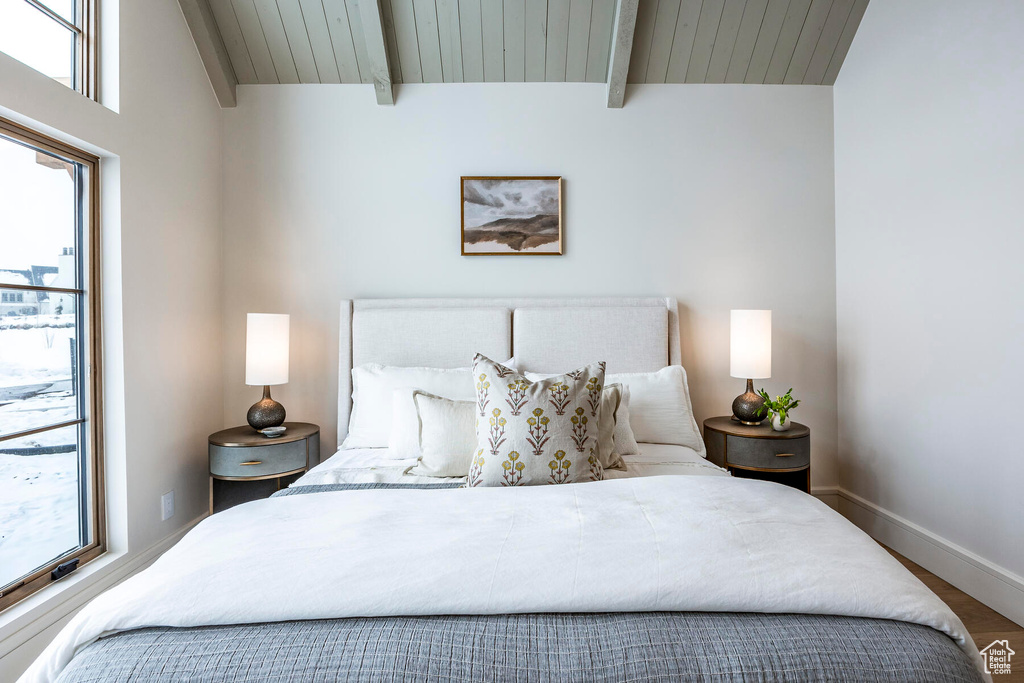 Bedroom with beamed ceiling, wood ceiling, hardwood / wood-style flooring, and multiple windows