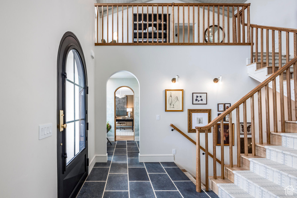 Entryway with a high ceiling and dark tile floors