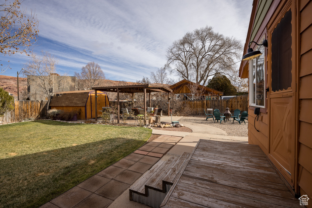 View of yard with a wooden deck and a patio