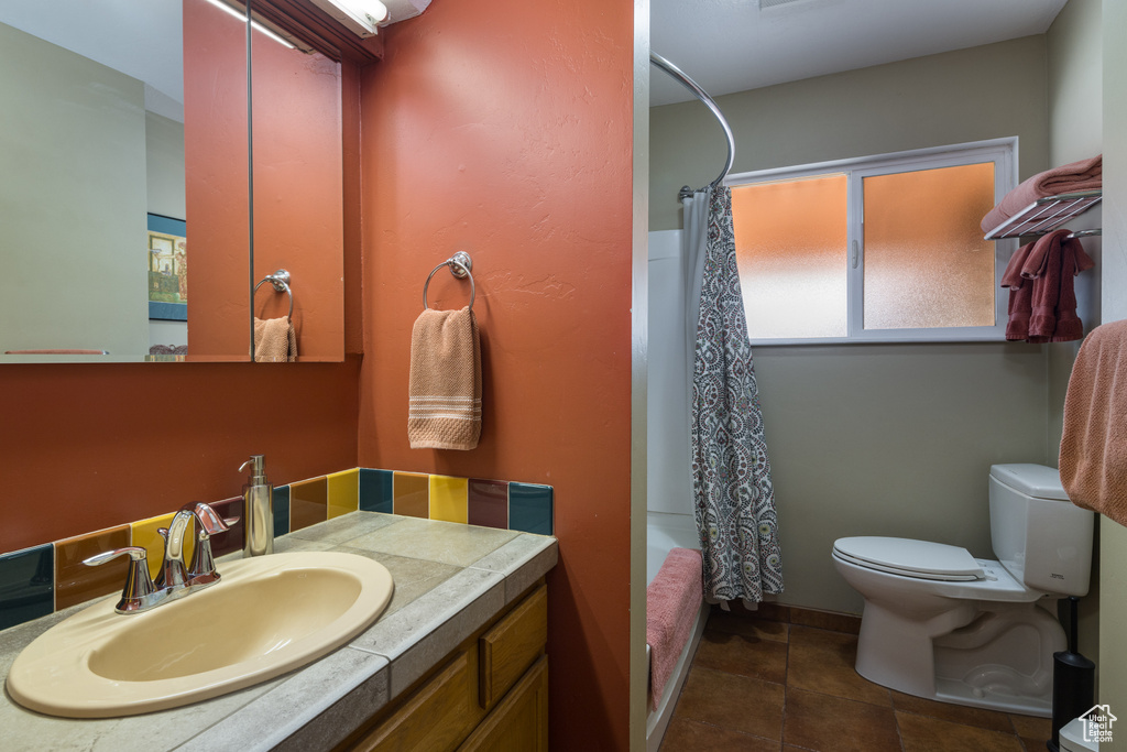 Full bathroom with shower / bath combination with curtain, toilet, vanity with extensive cabinet space, and tile flooring