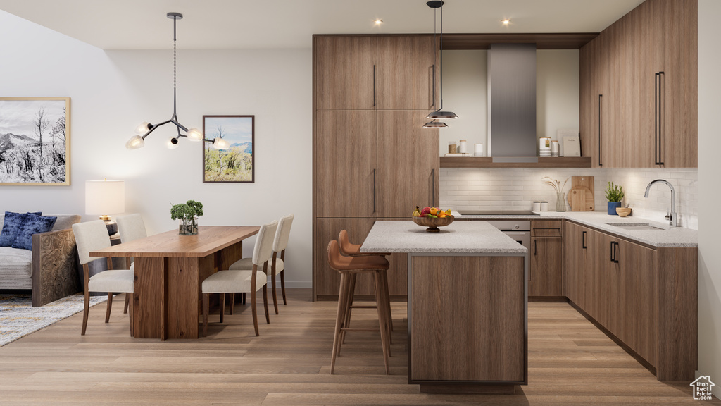 Kitchen featuring a breakfast bar, pendant lighting, light hardwood / wood-style flooring, and a center island