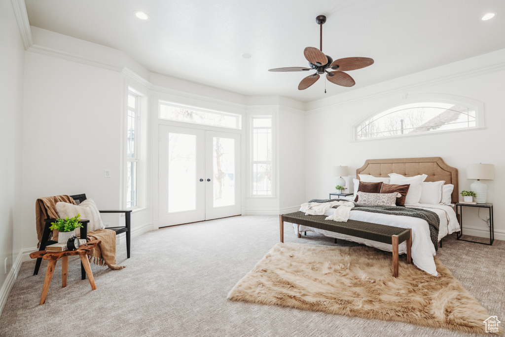 Bedroom featuring multiple windows, french doors, light colored carpet, and ceiling fan