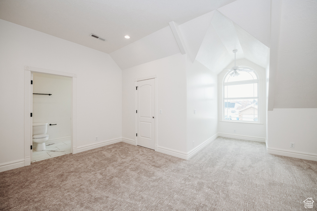 Additional living space featuring vaulted ceiling, light colored carpet, and ceiling fan