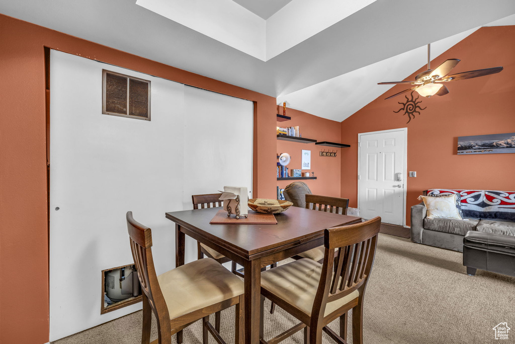 Dining space featuring vaulted ceiling, light carpet, and ceiling fan