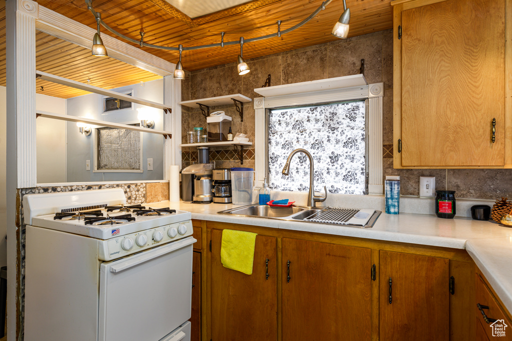 Kitchen with sink, wooden ceiling, white range with gas stovetop, and backsplash