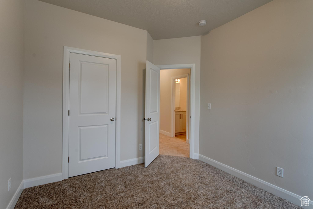 Unfurnished bedroom featuring light carpet