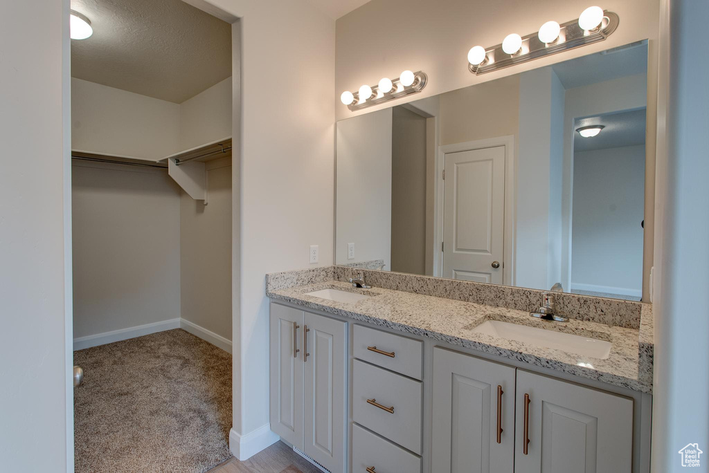 Bathroom featuring vanity with extensive cabinet space and double sink