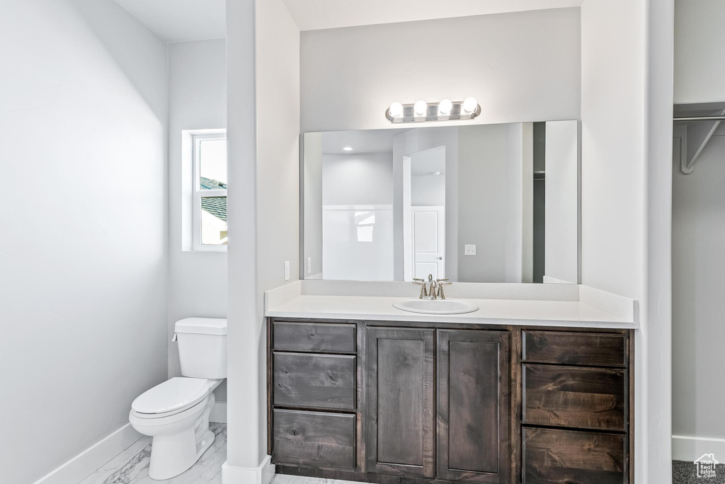 Bathroom featuring toilet, vanity, and tile flooring